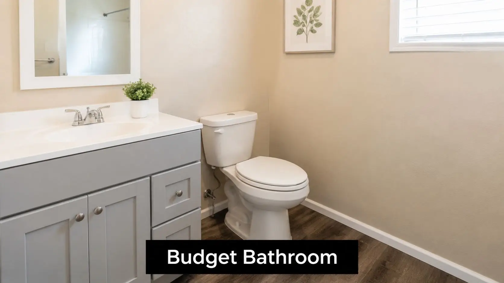 A modern, bright, small bathroom featuring a grey vanity cabinet, a white toilet, and minimalist wall decor.
