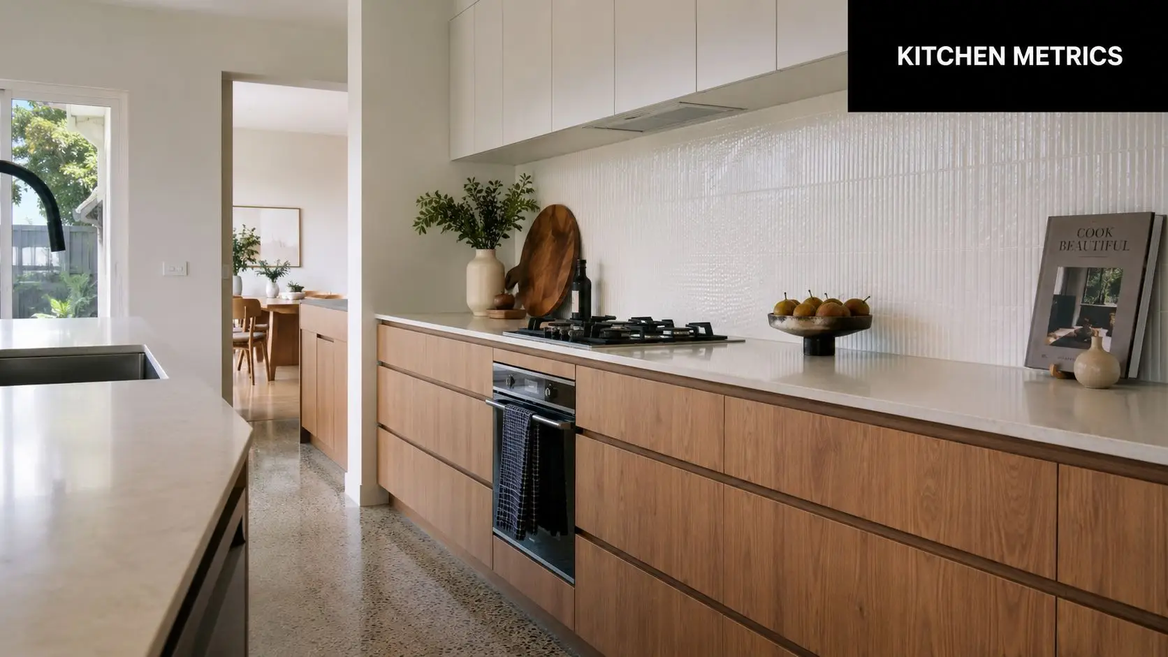 A modern minimalist kitchen featuring wood grain cabinets, white countertops, and a sleek built-in oven design.
