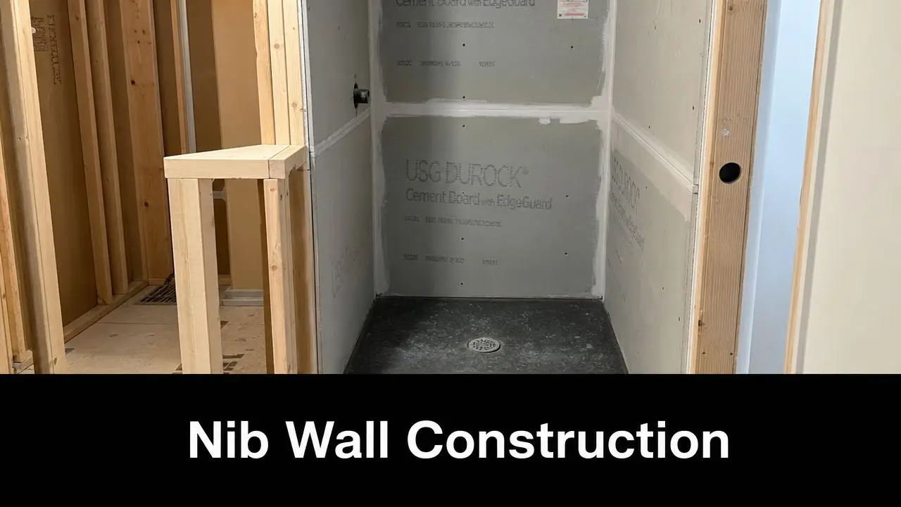 A wooden framed nib wall structure standing next to an unfinished tiled shower enclosure during construction.