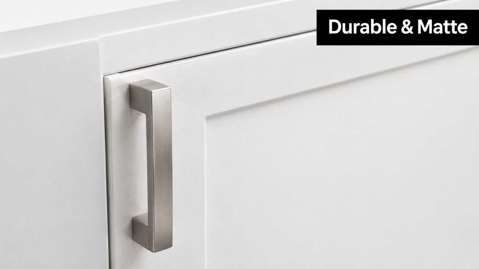 A close up view of a sleek, matte white cabinet door with a modern brushed metal handle.
